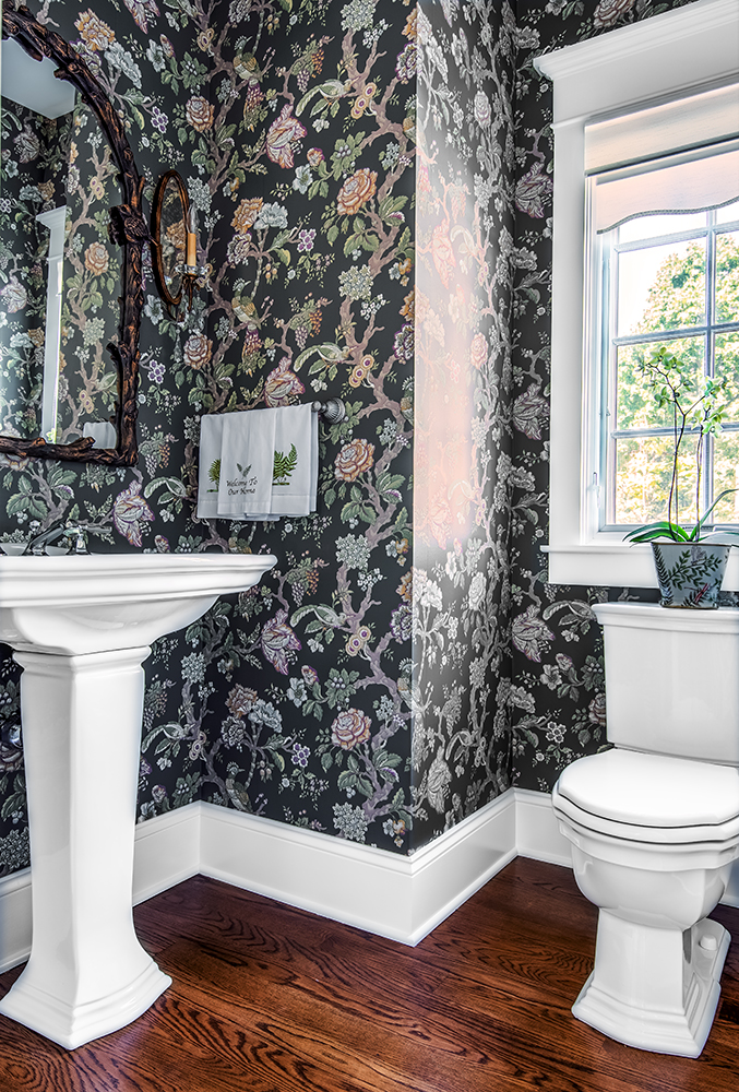 Guest bath with dark floral wallpaper and white pedestal sink