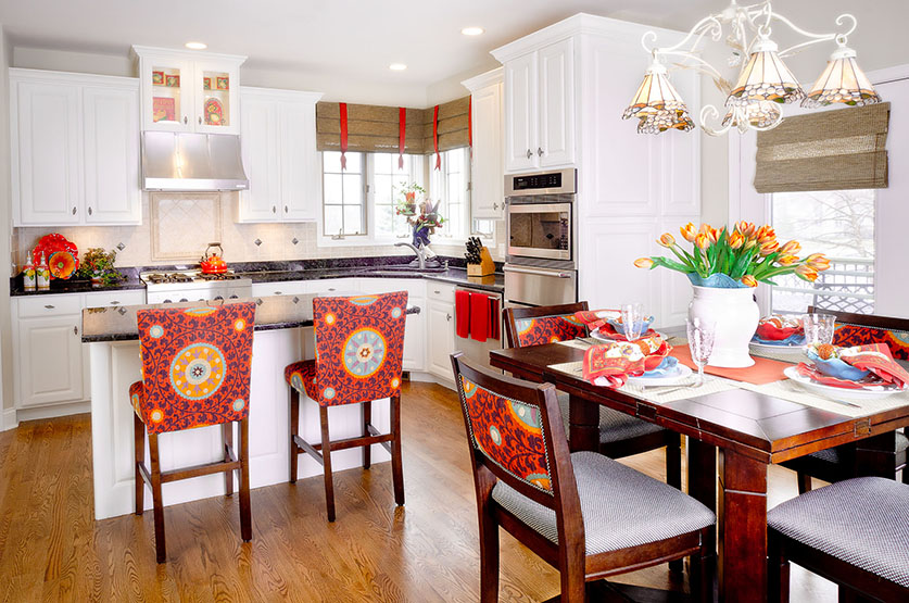 Remodeled kitchen with white cabinets and vibrant orange upholstered seating