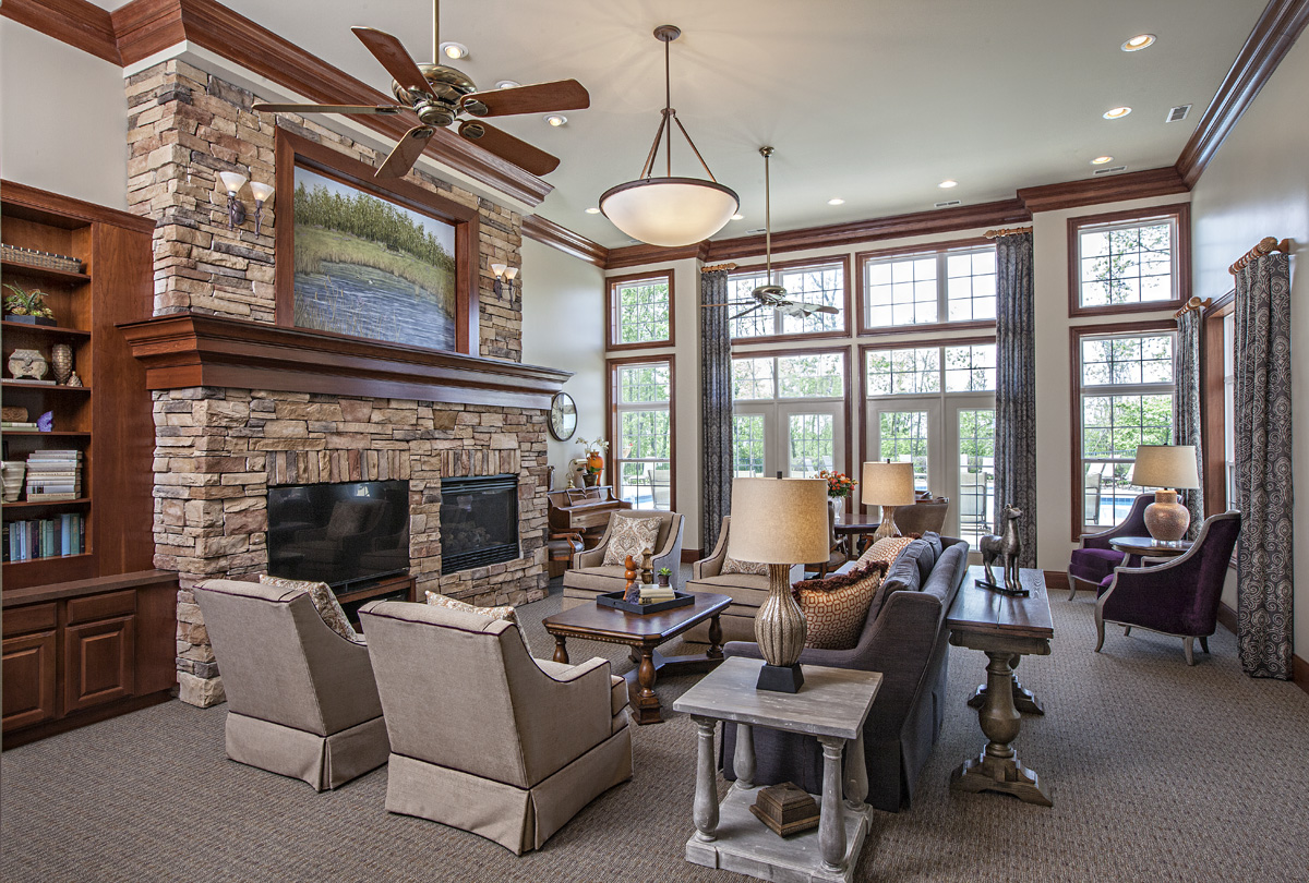Lobby of senior home with several sofas and armchairs in front of large stone fireplace