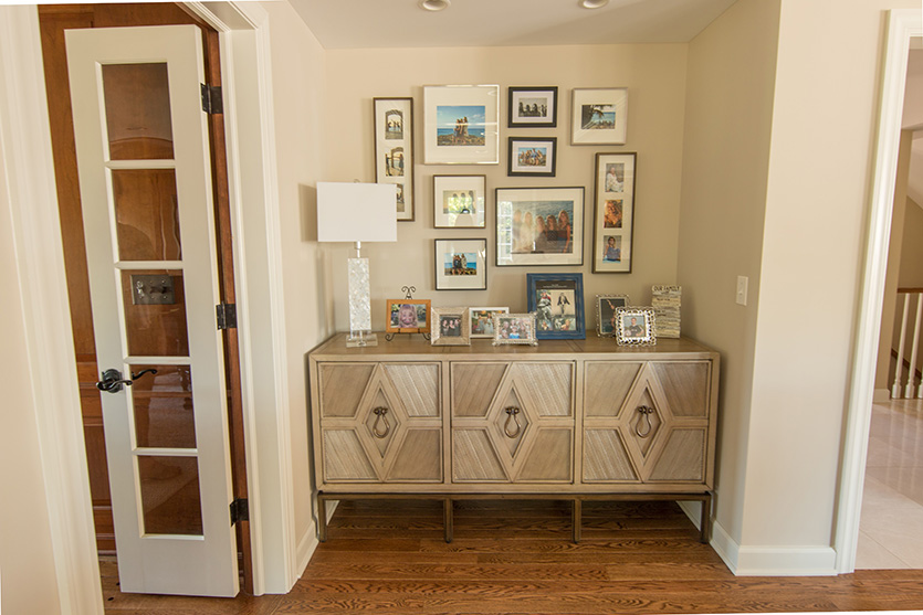 Family photo wall display over sideboard in an alcove
