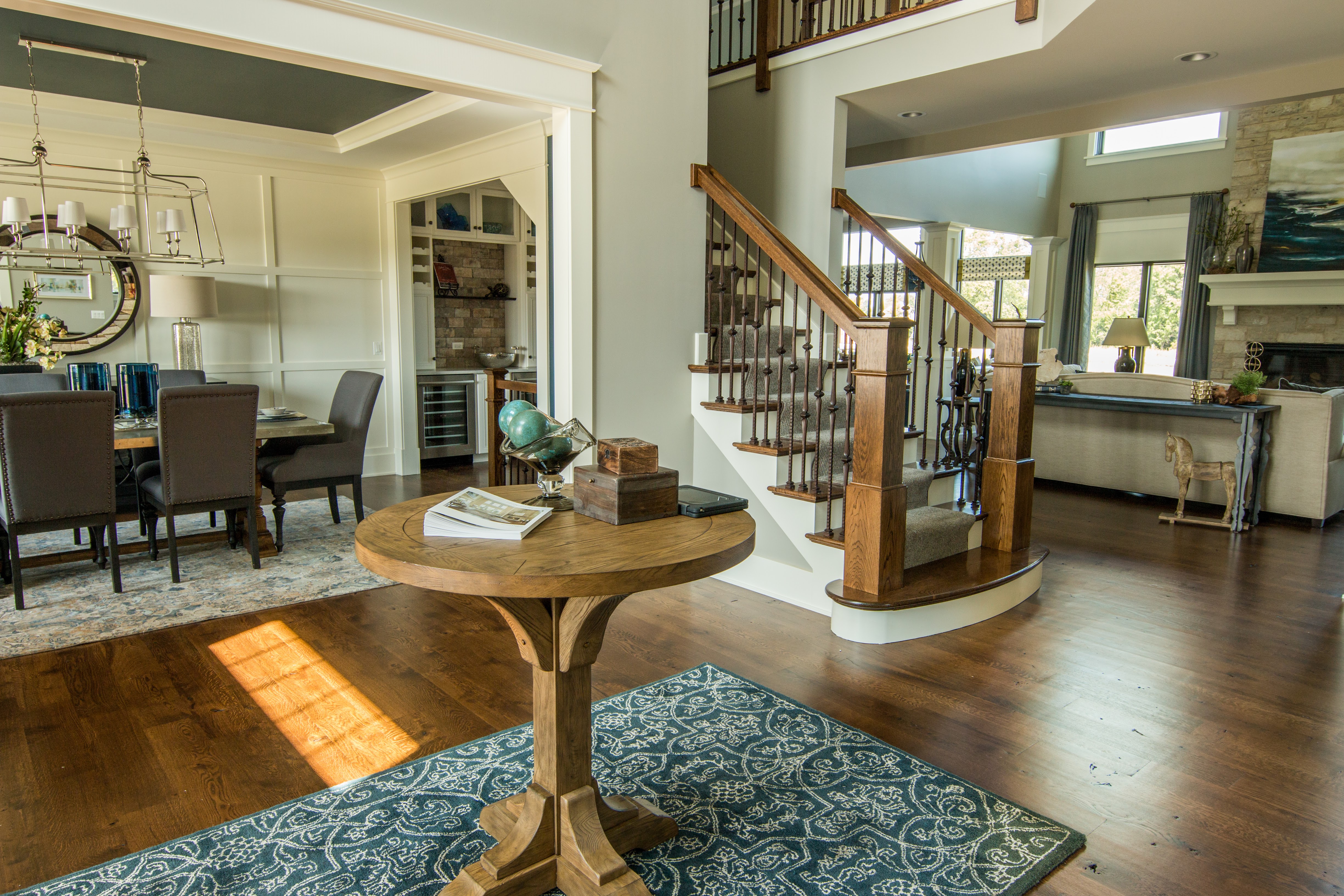 Model home entry with round table and blue rug