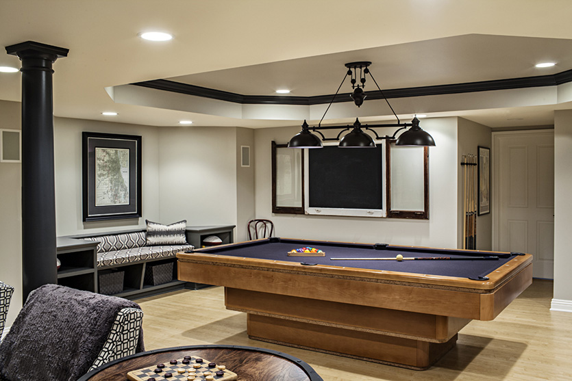 Wood pool table with navy blue felt and tripe pendant light fixture