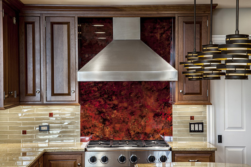 Dark red stone backsplash behind a stainless cooktop