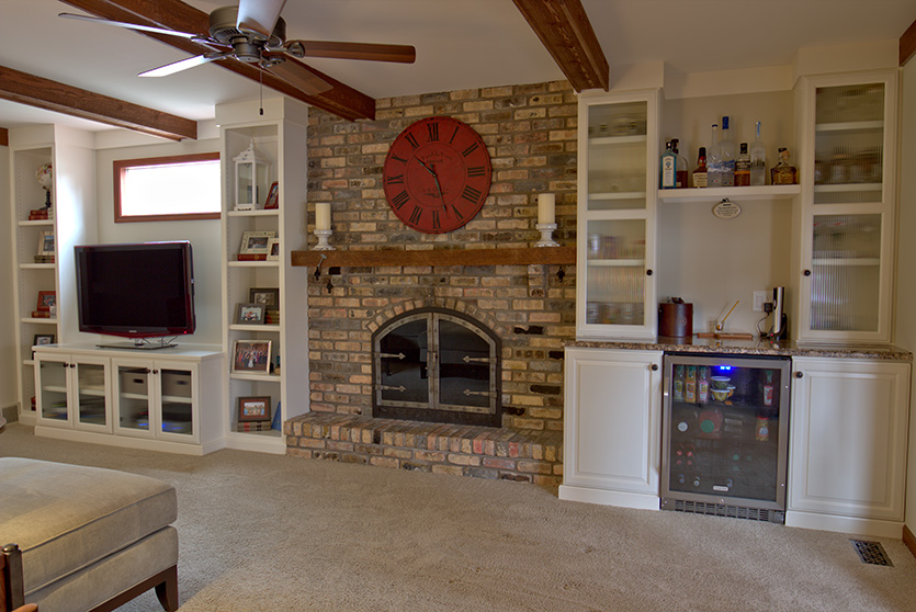 Brick fireplace with built in bookcases and bar area with fridge