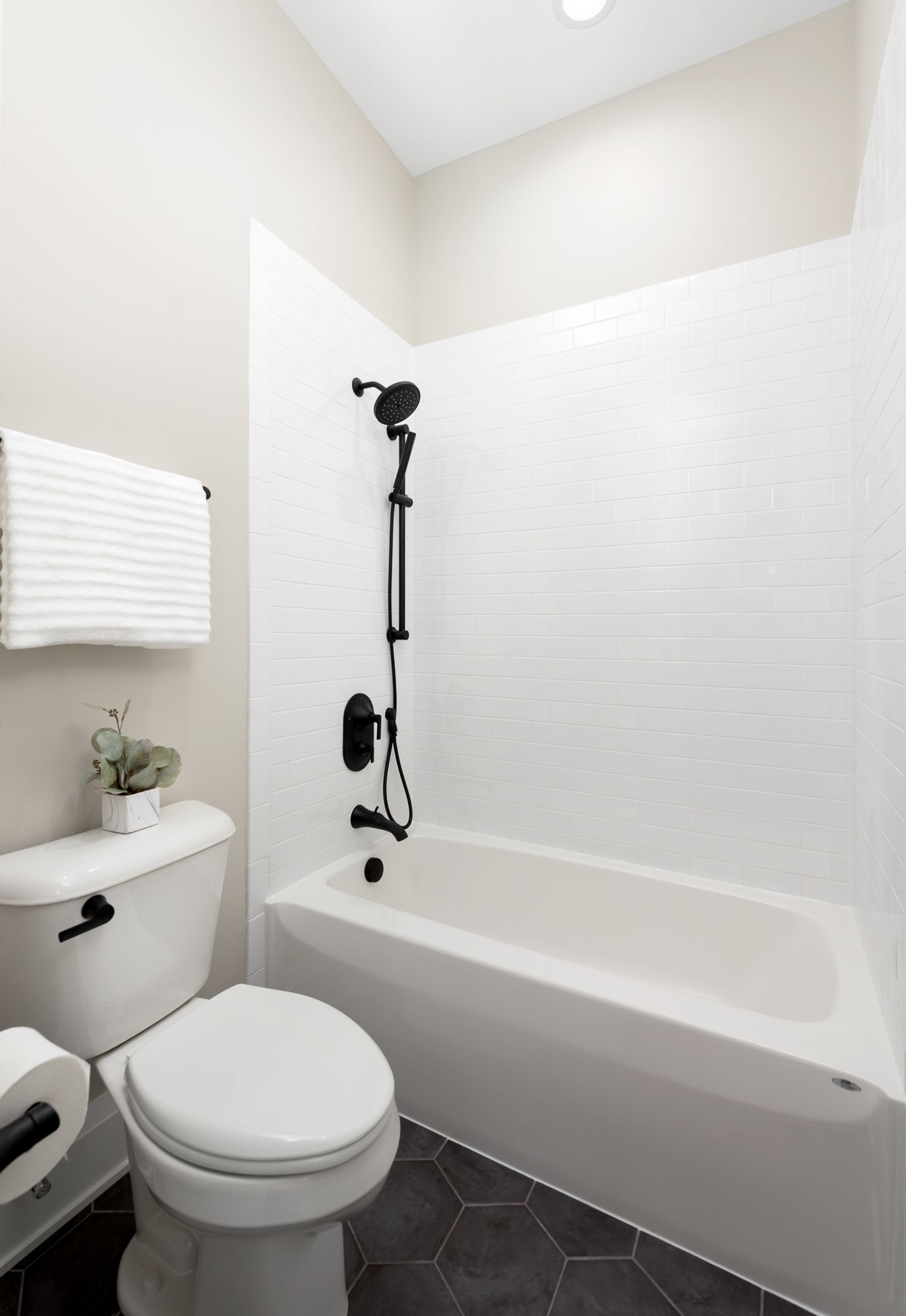 Bathroom with white tile and black plumbing fixtures