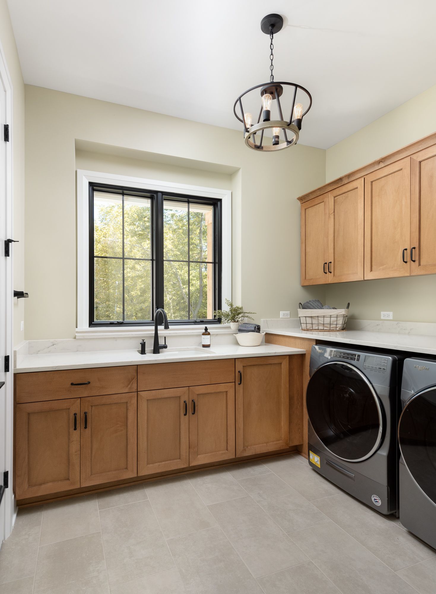 Laundry room with wood cabinets and modern farmhouse lighting