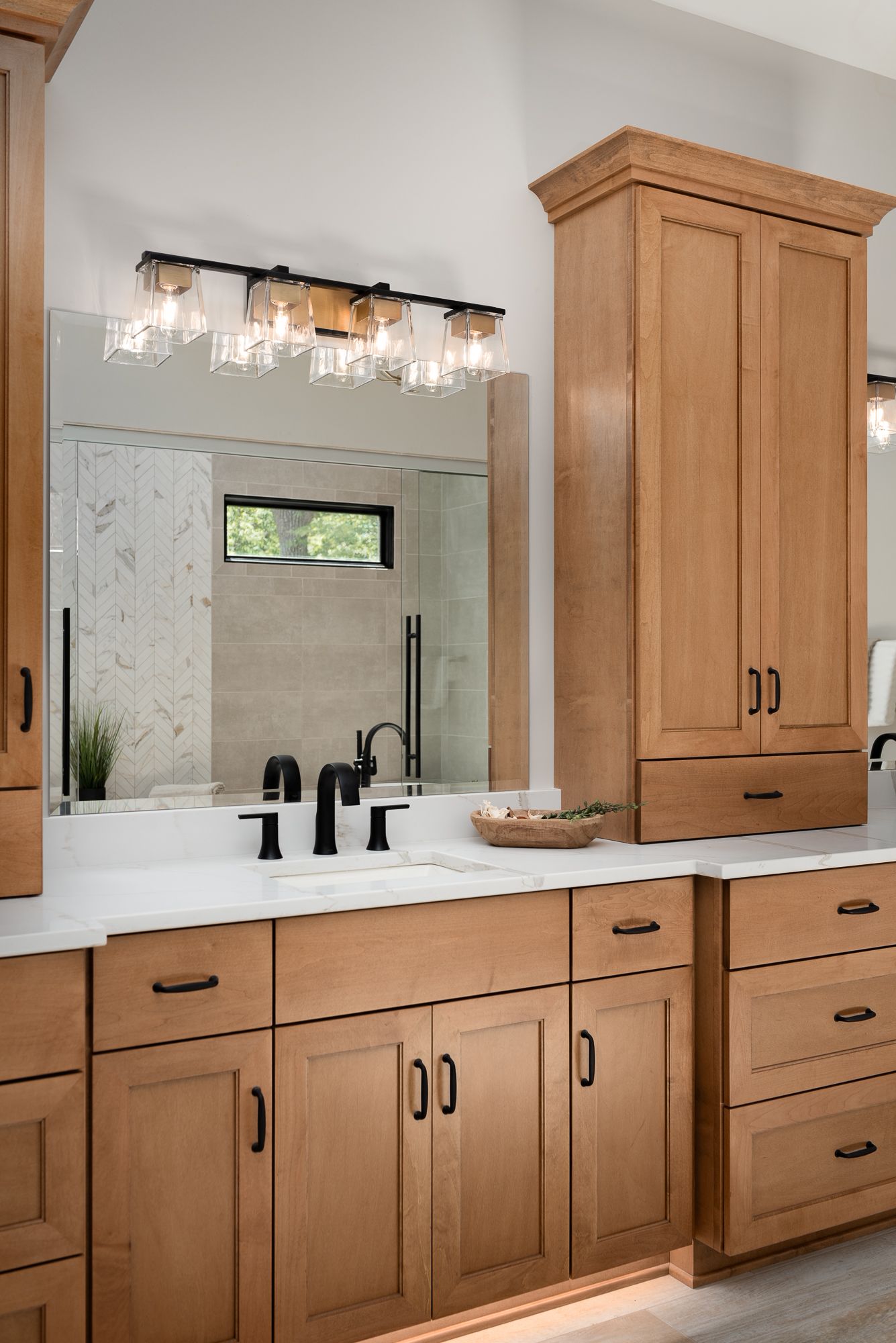 Wood master bathroom vanity with black hardware and vanity lighting
