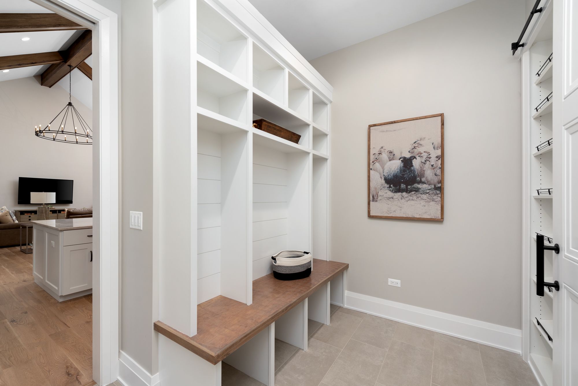 Mudroom with white built ins, bench with cubbies and sheep artwork