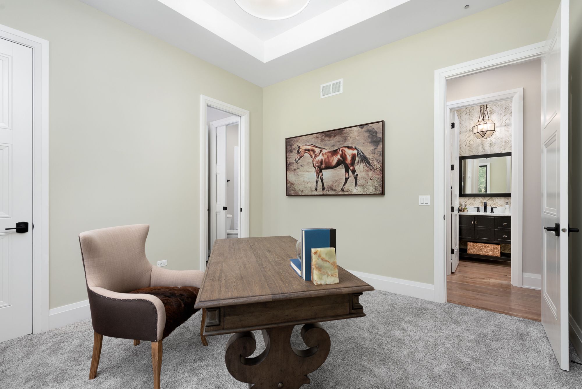 Home office with wood desk and horse artwork