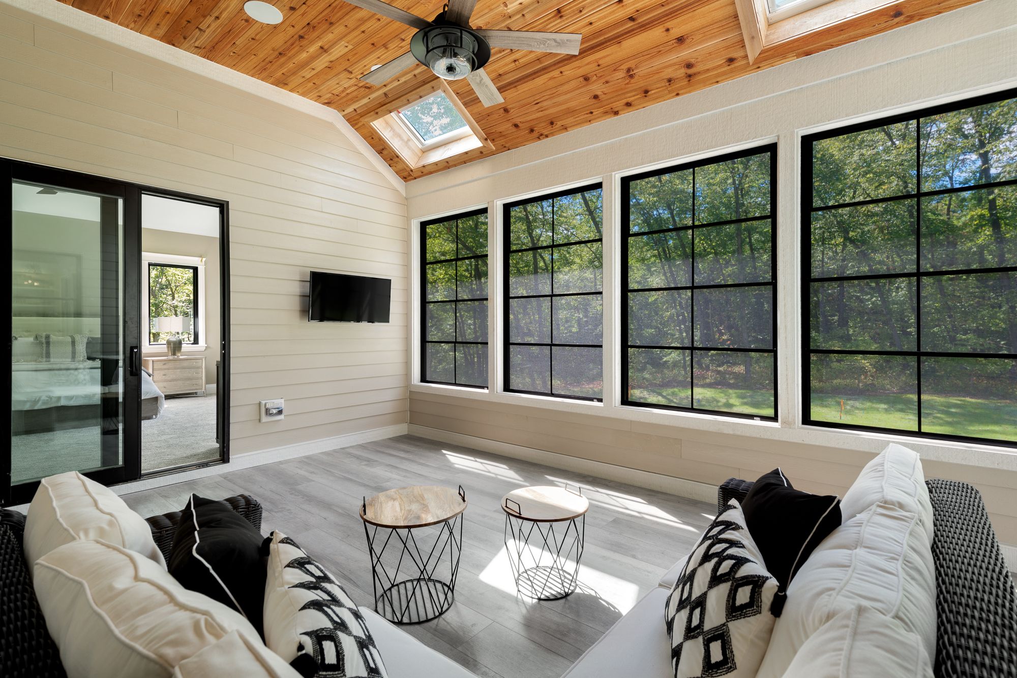 Sunroom with wood ceiling, sky lights and black window frames